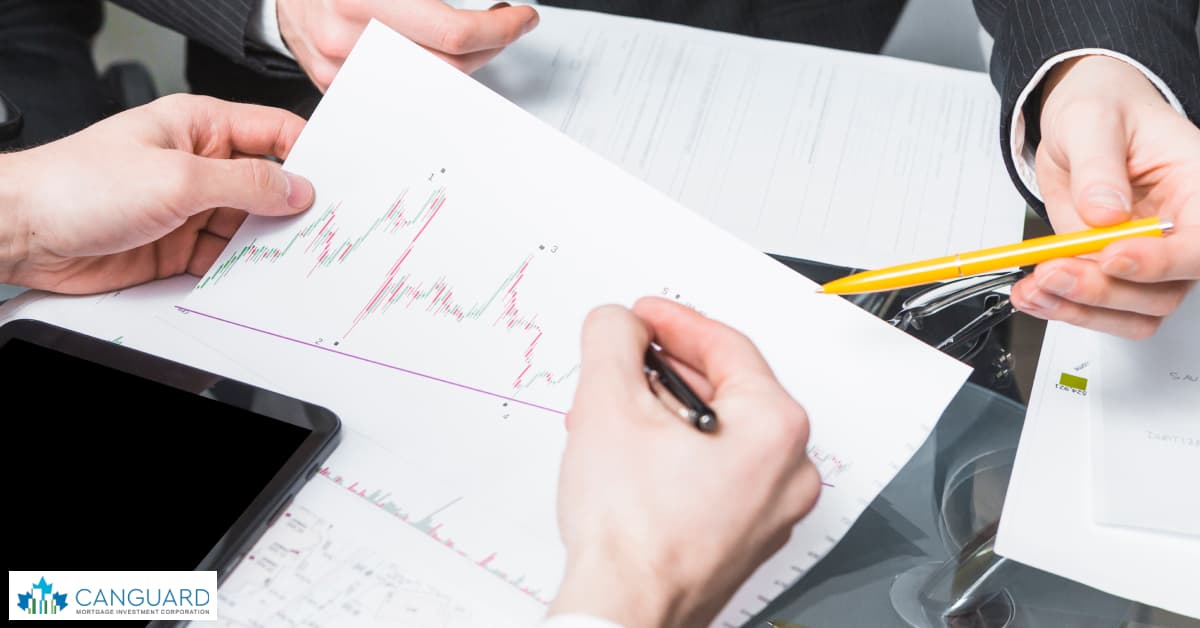 a group of investors looking at charts on a laptop.