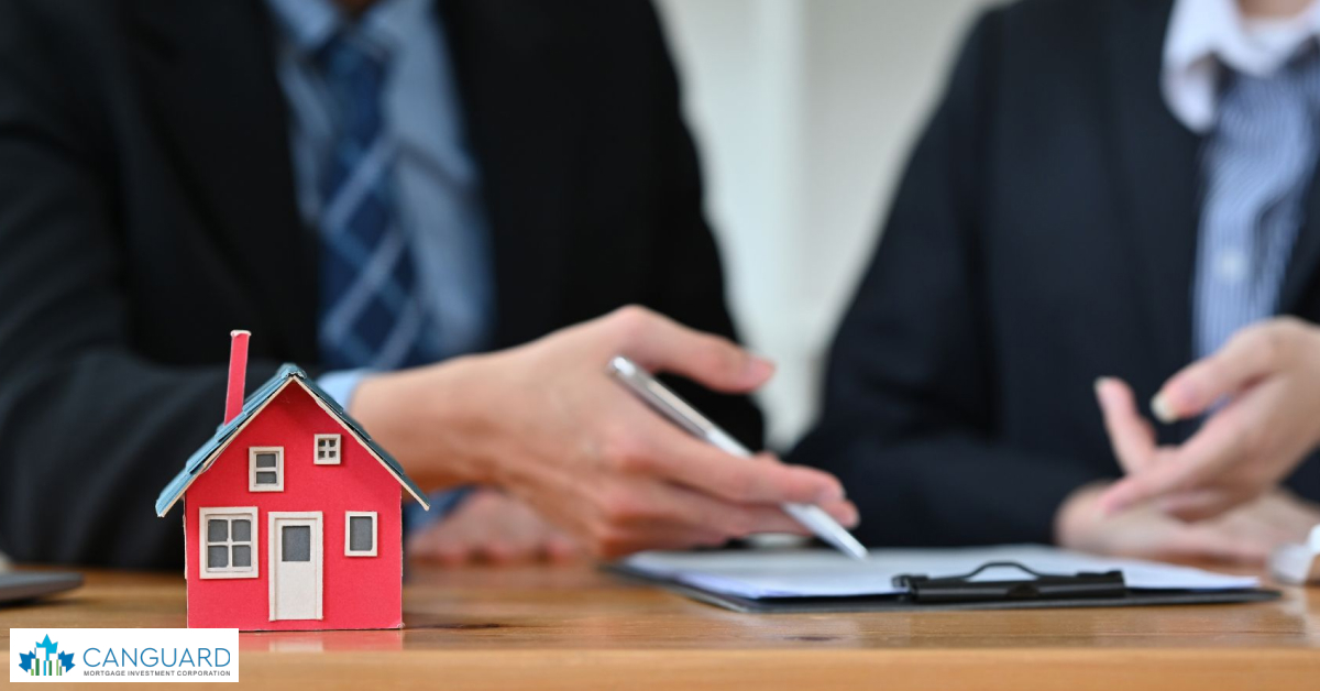 Business partners sealing a deal over a desk with a laptop and house model, representing identifying reputable lenders in MIC.