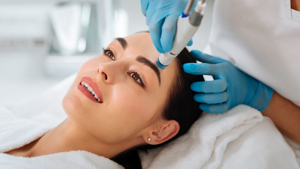 Delighted nice woman enjoying the hydrafacial procedure