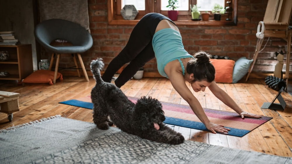 Woman doing yoga with her dog