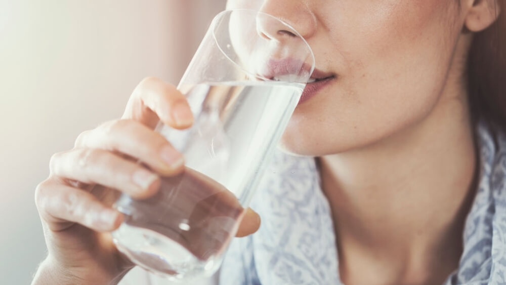 Young woman drinking pure glass of water
