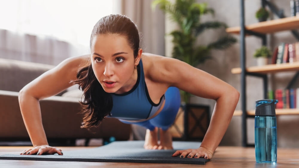 Lady doing push ups while workout at home