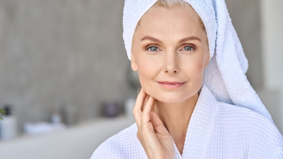 Mid-age woman touching face with tighten skin