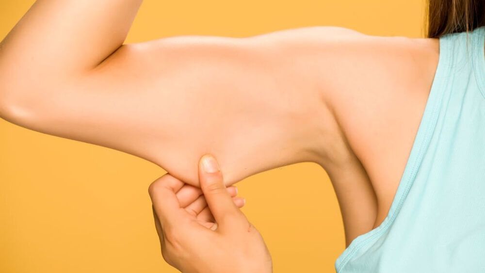 Young woman pinching fat on her hand