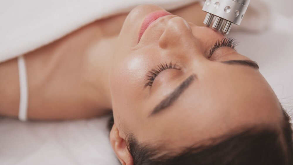Beautiful young woman getting facial skincare treatment