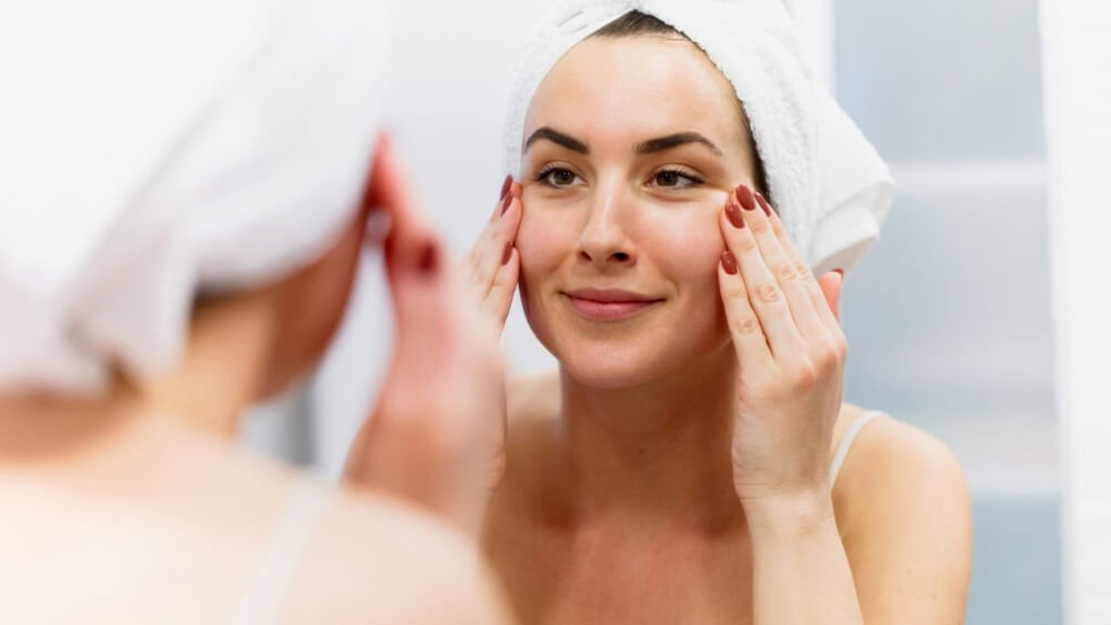 Woman tightening her skin in front of mirror