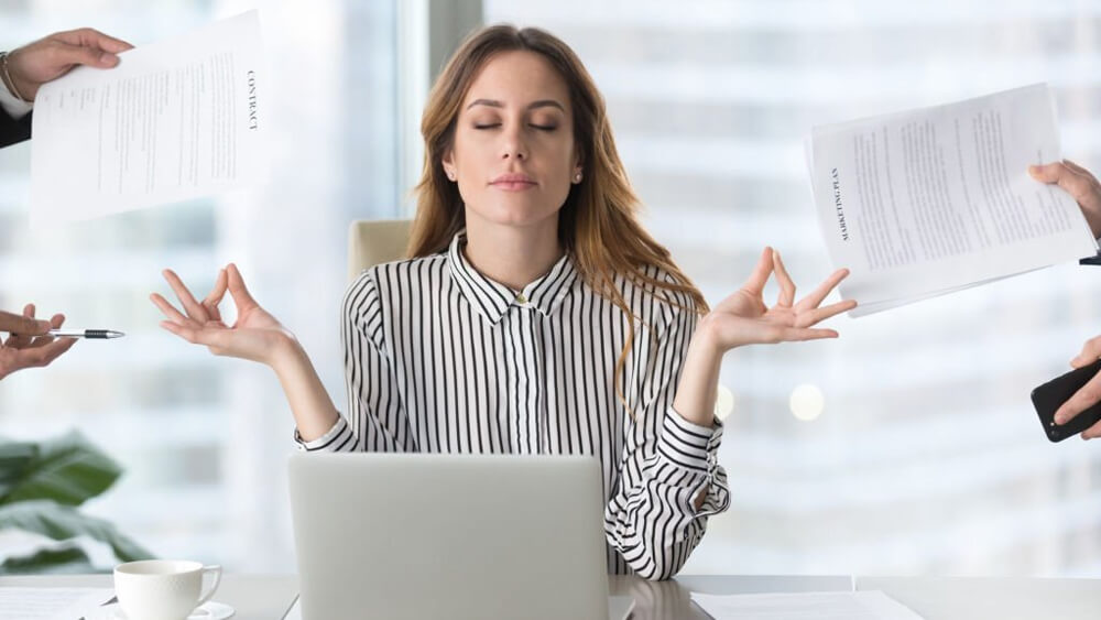 Calm female meditating and avoiding stressful job