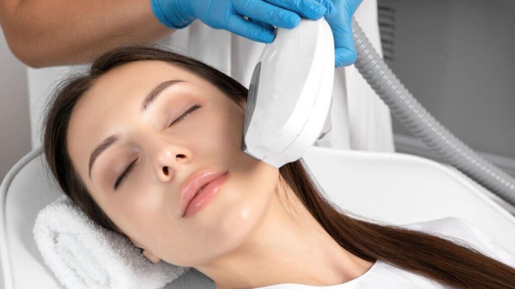 Hair removal procedure on a woman's face by a beautician