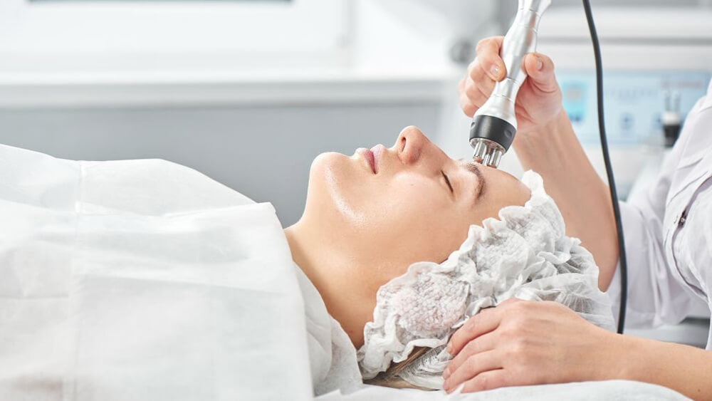 Professional beautician conducts session of radio frequency