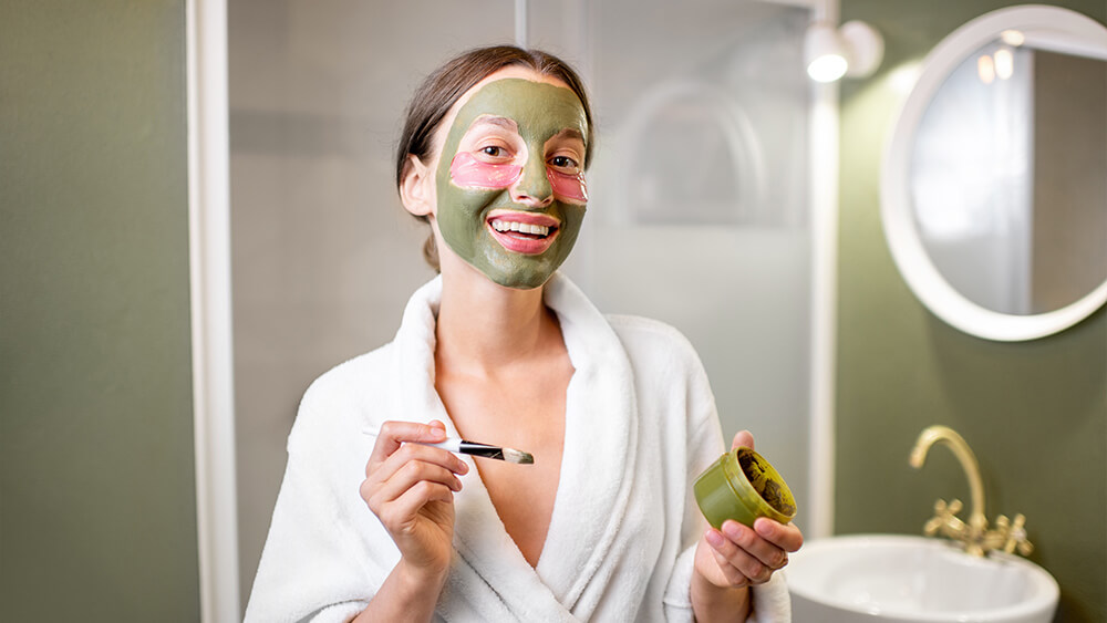 Woman with facial mask and patches in the bathroom