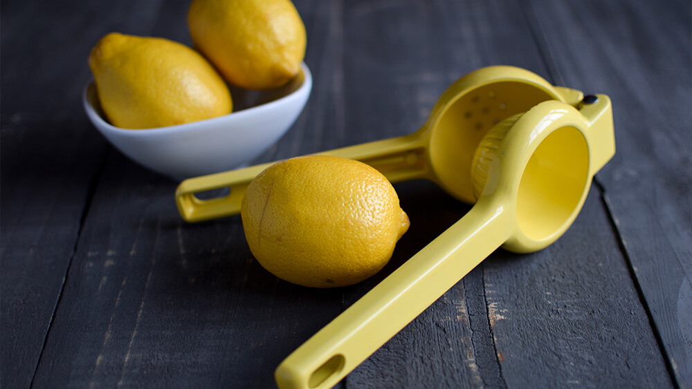 Lemons and a lemon juicer on a wooden background