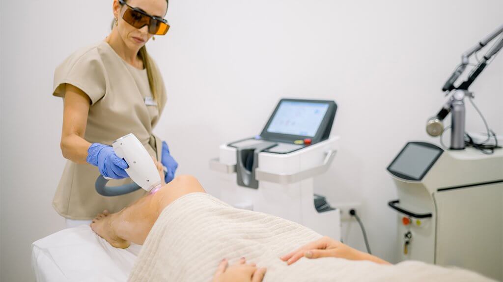 Beautician doing IPL treatment for female client