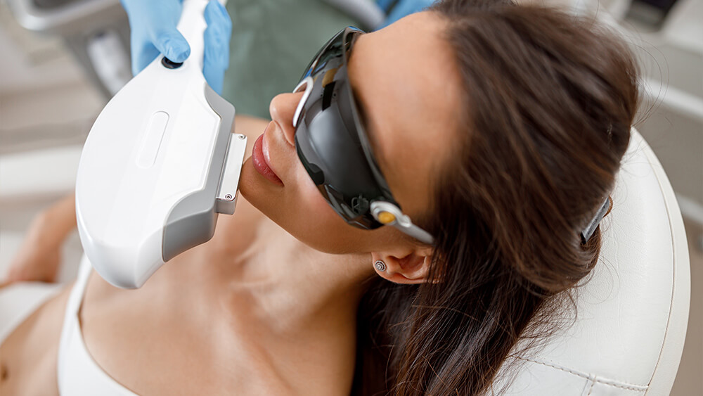 Young woman getting IPL treatment on her face