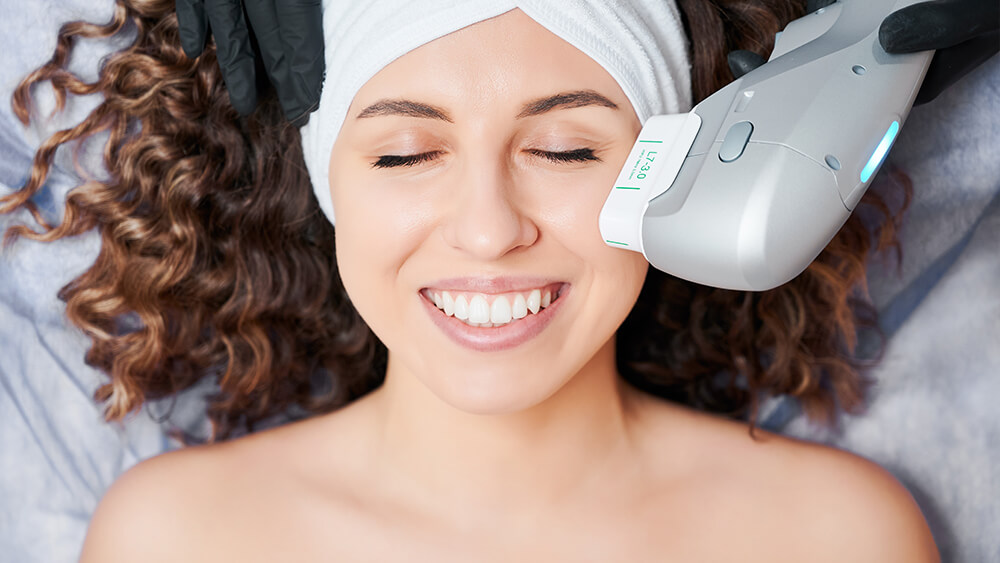 Cheerful young woman having face lifting procedure