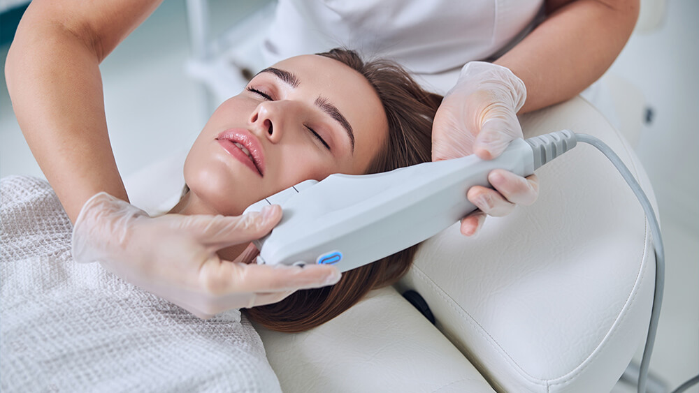 Young woman receiving professional IPL treatment on her face