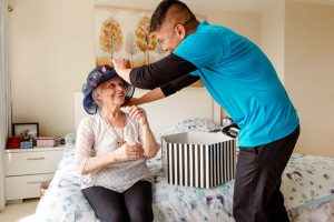 Hero Home Care caregiver fixing a hat for the client