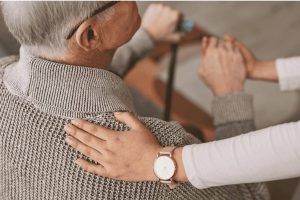 Image of a hand on a seniors back.